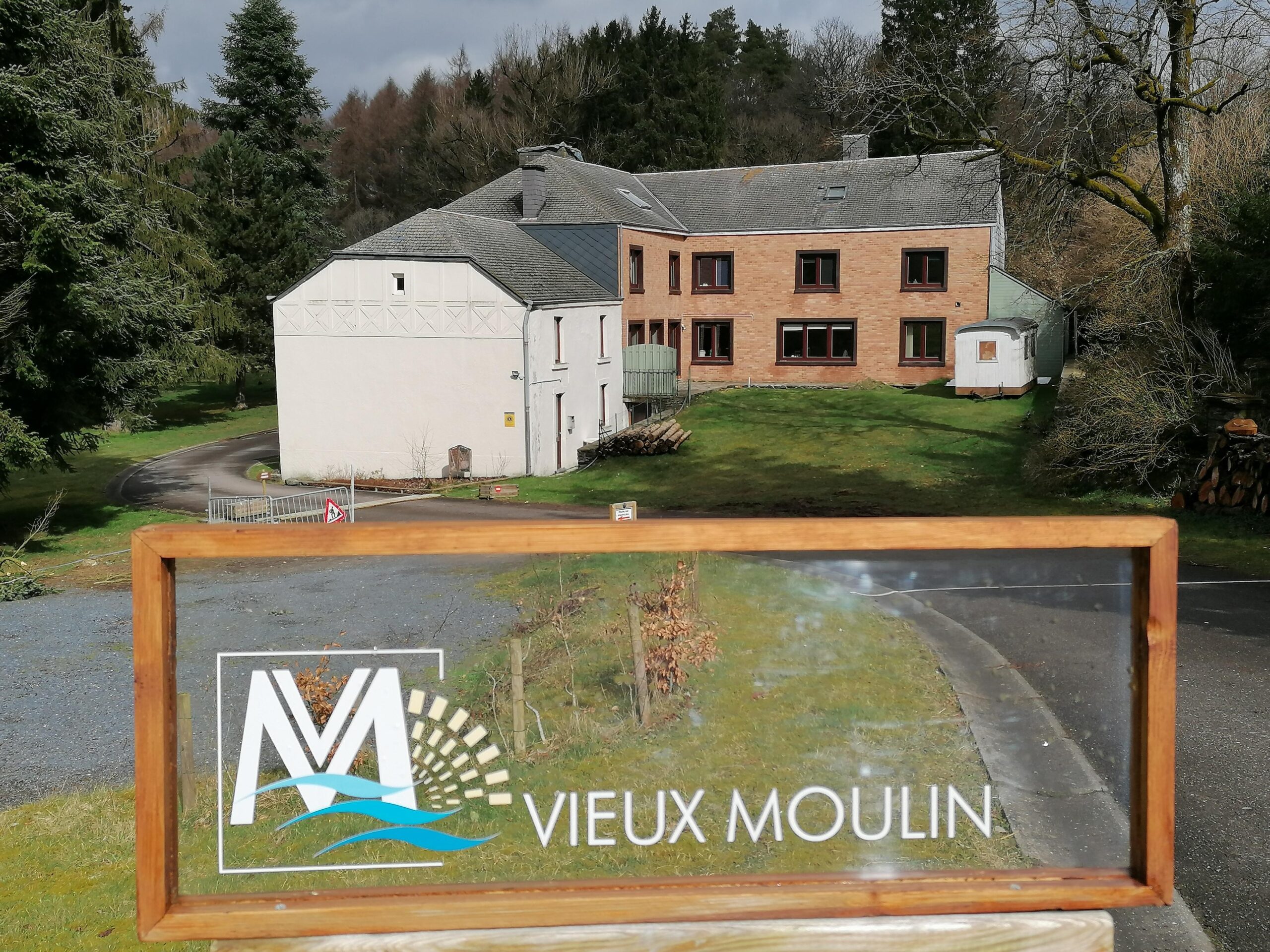 Autre côté de la maison le vieux moulin ou on peut apercevoir une grande enseigne en verre avec le nom et le logo