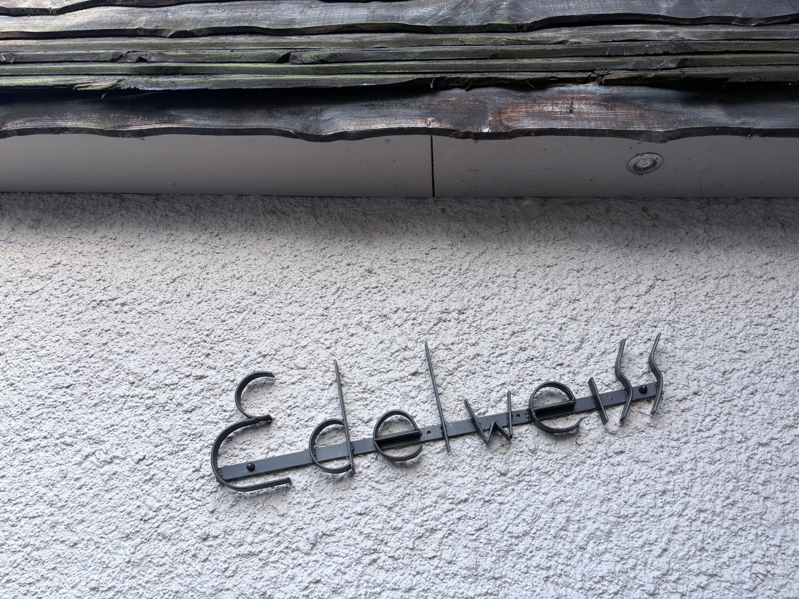L'enseigne de la maison Edelweiss accrochée sur le mur de celle-ci